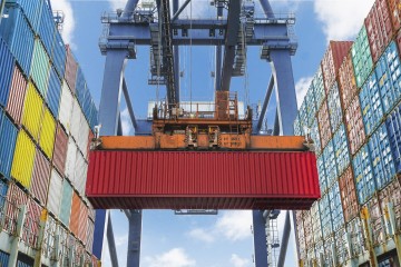 Shore crane lifts container during cargo operation in port